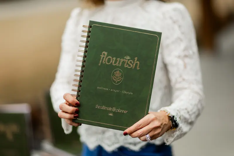 Michelle Johnson holding the Flourish planner in front of her
