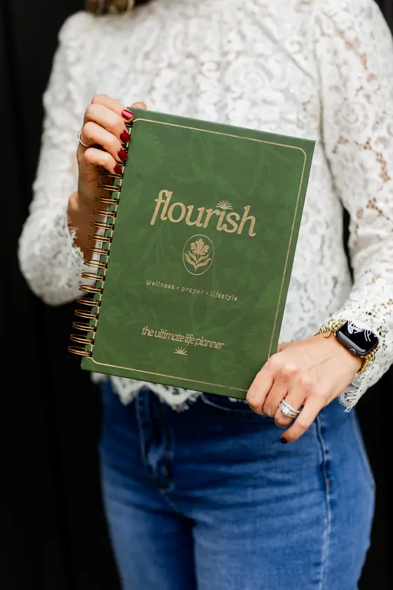 Flourish held against a lace blouse