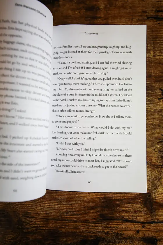 Zero Percent Chance open to a page of the memoir on a wooden table